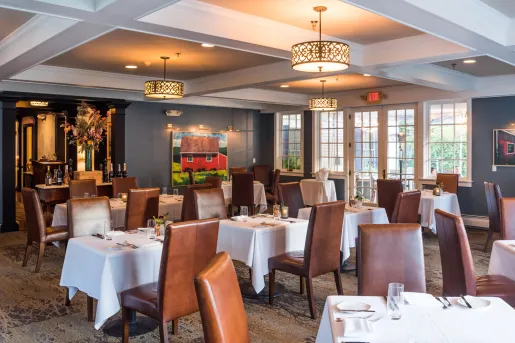 Indoor dining hall with brown, leather chairs and white tables