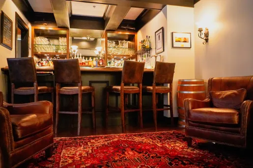 Indoor bar with leather stools and brown leather lounge chairs