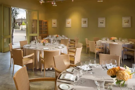 Dining room with tabls and glasses on wine with the door open on the left