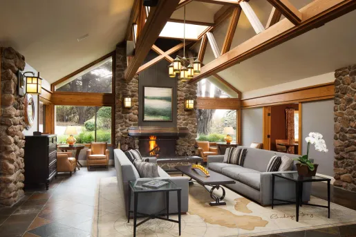 Indoor lobby with stone pillars and a fireplace in the center