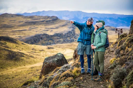 Man and two people pointing at an empty valley