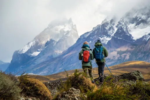 Two people walking through a valley filled with gravel