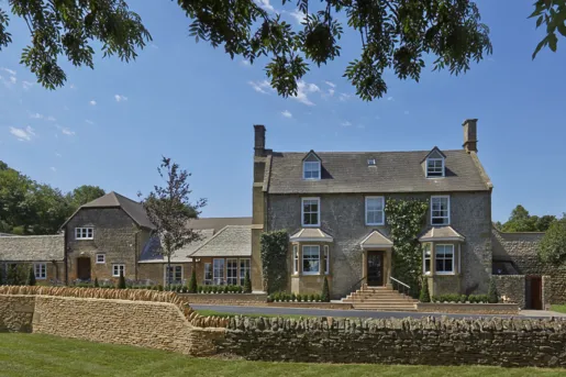 large stone house surrounded by low stone wall
