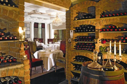 Red brick wine cellar with a dining area in the back