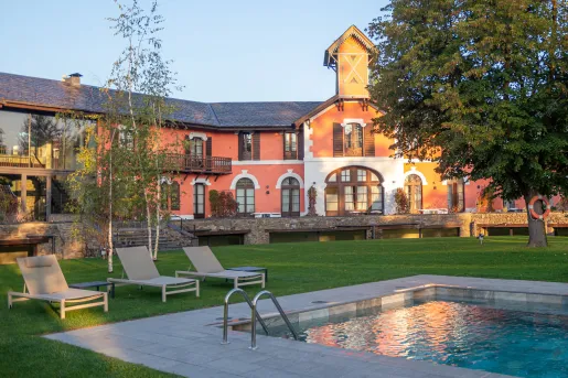 Outdoor pool with a building in the background with balconies