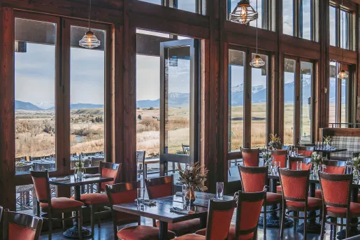 dining rooms with large windows opening up to a view