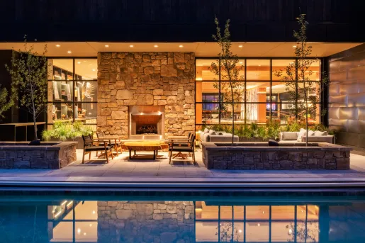 Outdoor lounge next to a pool and a fireplace