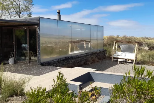 Building with mirror walls in the middle of a valley of plants