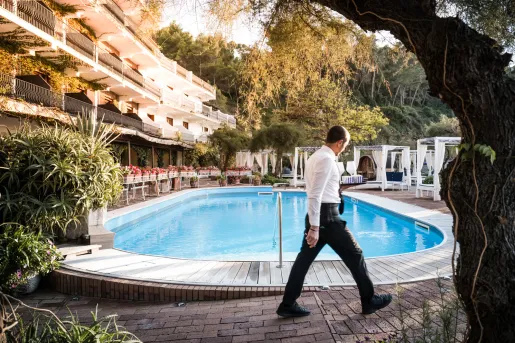 Outdoor pool with a waiter walking around the perimeter