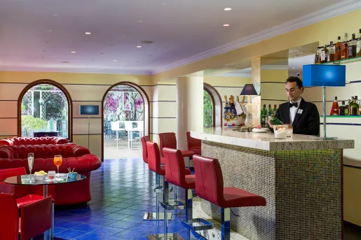 Bar and lounge with a bartender making drinks behind the counter