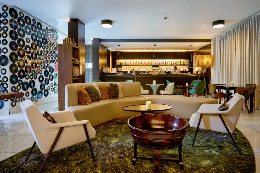 Indoor bar and lounge with circular sofas and a bar in the background