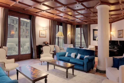 Indoor hotel lounge with blue and white cushioned chairs and white pillars