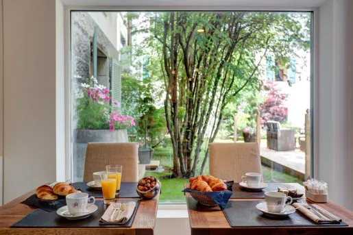 Dining table with cups of coffee and a large window in the background