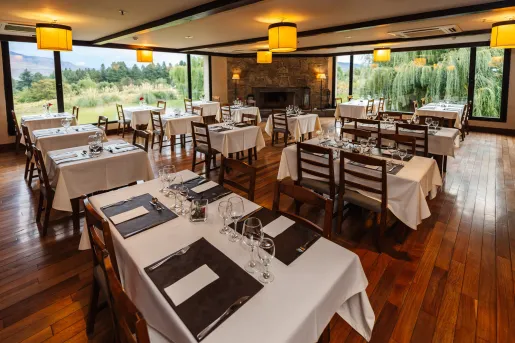 Indoor dining hall with square, white tables and large windows