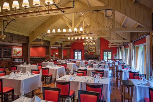 Restaurant dining hall with red chairs and white tables