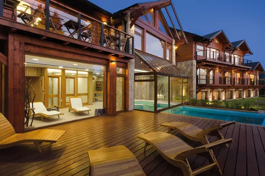 Exterior patio of a wooden cabin with an outdoor pool