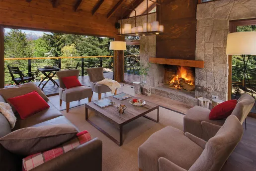 Cushioned chairs around a brick fireplace