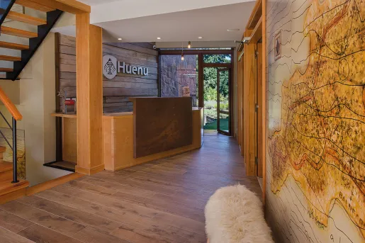 Hotel front desk with a wooden counter and a map on the wall
