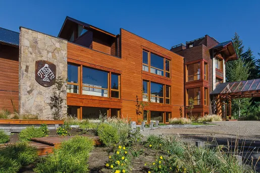 Hotel exterior with wooden wall panels and a grass area in front