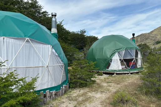 Small dome huts next to each other with a valley in the background