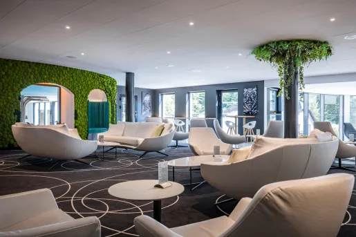 Room with large, cushioned sofas and large pillars covered in leaves