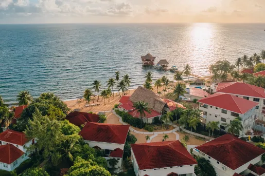 Sky view of red and white hotel building with the beach in view