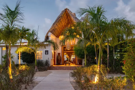 Exterior view of dimly lit hotel building with palm trees in front