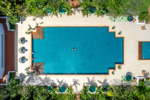 Sky view of outdoor pool with someone swimming