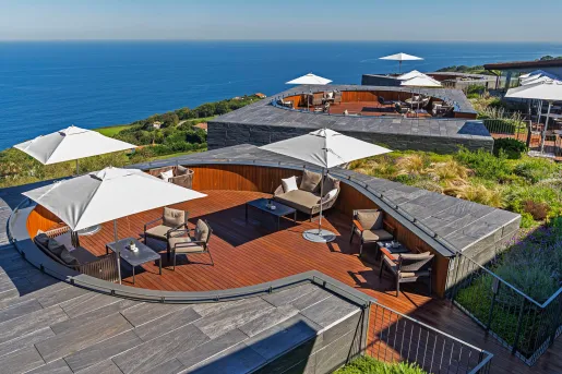 Outdoor patio with cushioned chairs and white umbrellas