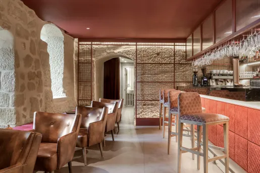 Bar and lounge with leather chairs, and a red bar counter to the right