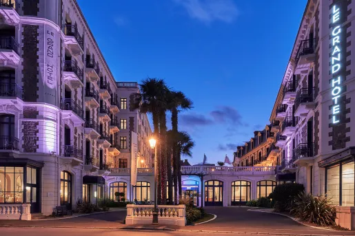 Exterior view of large hotel complex at night, illuminated by warm lights