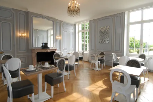 Room with wooden flooring and black and white chairs, with a small chandelier from the ceiling
