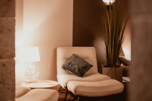 Upholstered chair with pillow and blanket on it