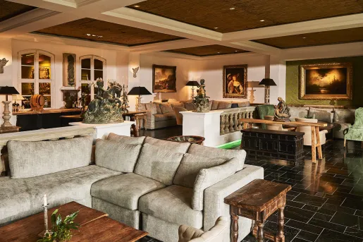Hotel lobby and seating area, with cushioned sofas, with copper statues around the room