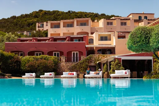 Outdoor pool with large beige and brown hotel buildings in the background