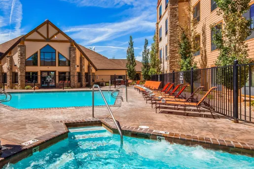 Outdoor pool of a hotel, surrounded by brown hotel buildings