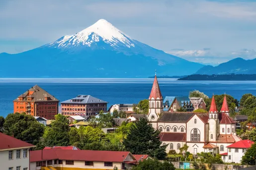 Small town with a lake and snow-capped mountain in the distance