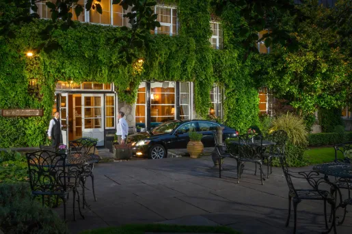 Outdoor car valet in front of a hotel with two men standing in front