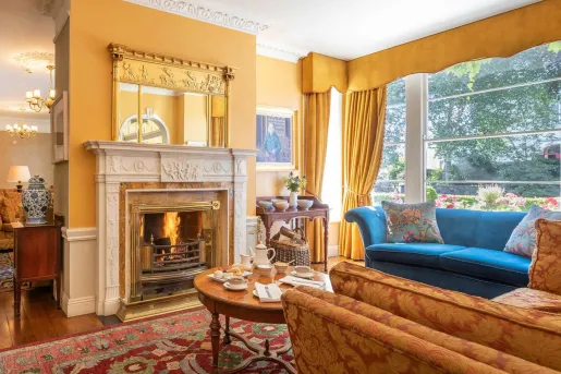 Seating area and lounge with cushioned sofas in front of a fireplace