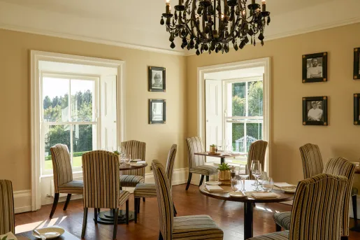 Restaurant dining area with circular tables and striped, beige chairs