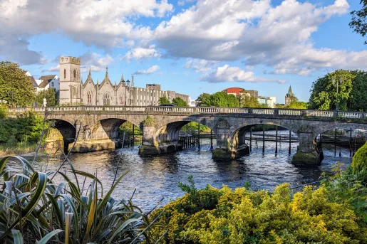 Stone bridge over a river leading to a castle-like building
