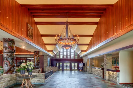 Hotel lobby entrance with stone flooring and large light fixture in the center