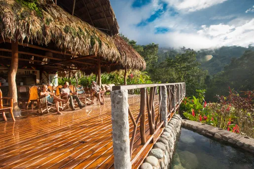 Outdoor patio with wooden and stone fencing, with mountains in the distance