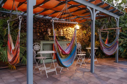 Outdoor patio with 3 hammocks hanging from ropes