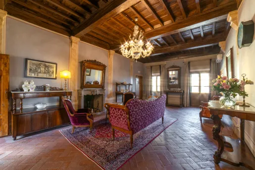 Room with tile flooring and red velvet chairs, and furniture along the walls