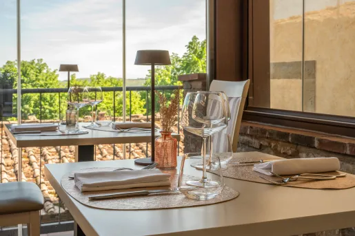 Square dining table with wine glasses and silverware