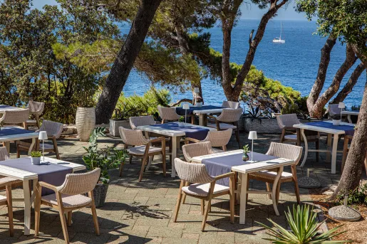 Outdoor patio on stone tiles, with the ocean in the background
