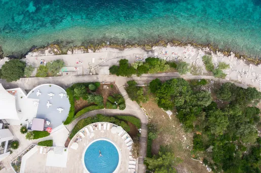 Sky view of an outdoor pool with the ocean in front