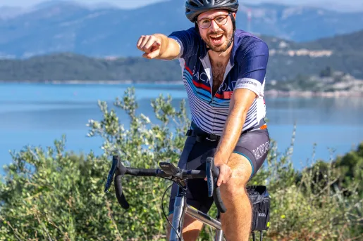 Man riding a bike, smiling and pointing