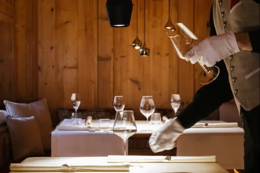 Waiter putting wine glasses on a dining table